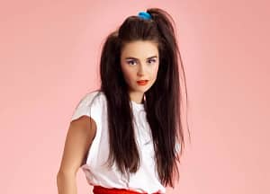 A 90s half-up hairstyle with a crimped half ponytail